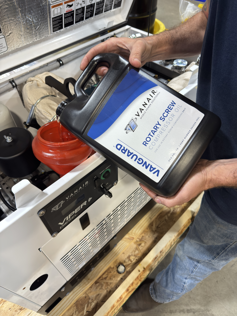 Pouring Vanair® Vanguard™ Oil Rotary Screw Compressor Oil into Viper™ Diesel Air Compressor